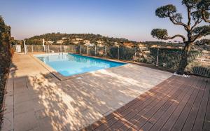a swimming pool on a patio with a tree at Bel appartement, terrasse, piscine, vue sur Golf in Sainte-Maxime
