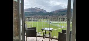 a balcony with a table and chairs and mountains at Donard View Penthouse in Newcastle