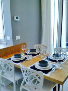 a wooden table with chairs and plates and wine glasses at Il Bordone - appartamento con vista mare in Manarola