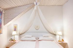 a bedroom with a white bed with two pillows at Apartments Ladka in Begunje na Gorenjskem