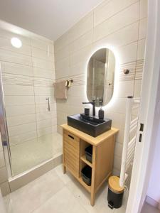 La salle de bains est pourvue d'un lavabo et d'une douche. dans l'établissement Somptueux appartement rénové en bord de mer, à Six-Fours-les-Plages