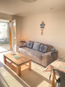 ein Wohnzimmer mit einem Sofa und einem Couchtisch in der Unterkunft Somptueux appartement rénové en bord de mer in Six-Fours-les-Plages