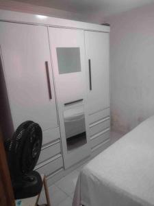 a bedroom with a bed and a chair next to a cabinet at Seu lar em Bonito-PE in Bonito