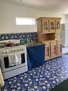 uma cozinha com um fogão branco e piso em azulejo azul em Playa El Obispo A La Marea building La Libertad em La Libertad
