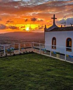 a church with the sunset in the background at Seu lar em Bonito-PE in Bonito