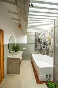 a bathroom with a tub and a sink at Tree of Life Resort in Bentota