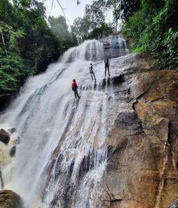 three people standing on top of a waterfall at Seu lar em Bonito-PE in Bonito