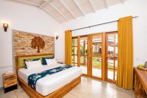 a bedroom with a bed and a window at Tree of Life Resort in Bentota