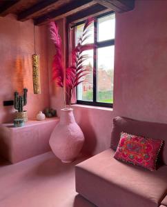 a pink room with a vase with a plant in it at Suite La Bonita 