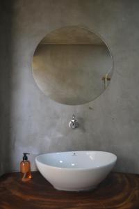 ein Badezimmer mit einem weißen Waschbecken und einem Spiegel in der Unterkunft Hakuna Matata Glamping in Bacalar