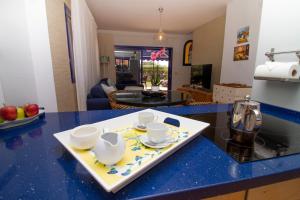 - un comptoir avec un plateau avec des tasses et des soucoupes dans l'établissement Sea View Meloneras Terrace Duplex +Wifi +Barbecue, à Meloneras
