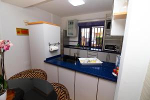 une petite cuisine avec un comptoir bleu dans l'établissement Sea View Meloneras Terrace Duplex +Wifi +Barbecue, à Meloneras