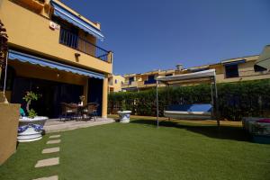 een achtertuin met een gazon en een prieel bij Sea View Meloneras Terrace Duplex +Wifi +Barbecue in Meloneras