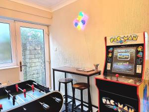 Spacious 4 Bed Holiday Home with Hot Tub & Parking near Matlock Peak District في Crich: غرفة مع آلة pinkall وطاولة