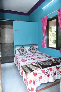 a bedroom with a bed and a blue wall at NISARG HOME STAY near Bus Stand Malvan in Malvan