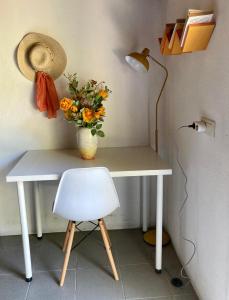 a desk with a vase of flowers and a lamp at Casa da Penalva in Santa Cruz do Lima