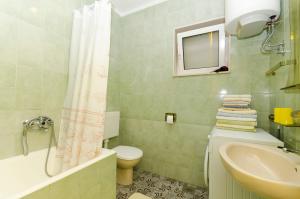 a bathroom with a sink and a toilet and a shower at Apartments Simon in Bol