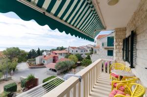 a balcony with chairs and a view of a street at Apartments Simon in Bol