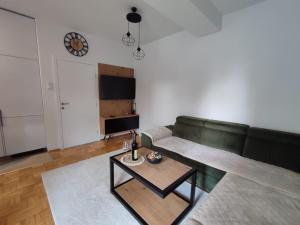 a living room with a green couch and a table at Apartman Golemovic in Banja Luka