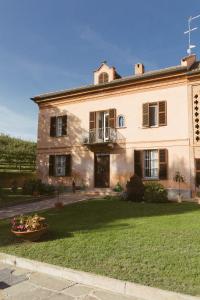 ein großes Backsteingebäude mit einem Balkon und einem Hof in der Unterkunft Apart-Agriturismo "La Colomba" Nizza Monferrato in Nizza Monferrato