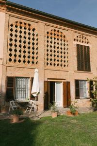 ein Backsteingebäude mit einem Regenschirm und einem offenen Schirm sidx sidx in der Unterkunft Apart-Agriturismo "La Colomba" Nizza Monferrato in Nizza Monferrato