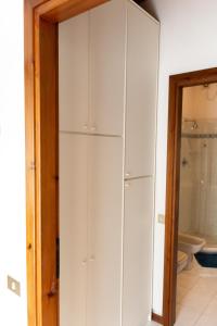 armadio bianco in bagno con servizi igienici di Apart-Agriturismo "La Colomba" Nizza Monferrato a Nizza Monferrato