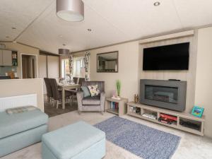 a living room with a flat screen tv and a couch at Rowan in Crieff