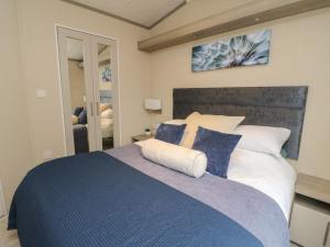 1 dormitorio con 1 cama grande con almohadas azules y blancas en Rowan, en Crieff