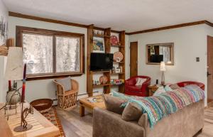 ein Wohnzimmer mit einem Sofa und einem Tisch in der Unterkunft Riverside Retreat 12 at Taos East in Taos