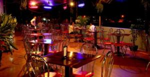 فندق كينغ فاي في باتامبانغ: مجموعة من الطاولات والكراسي على الفناء في الليل