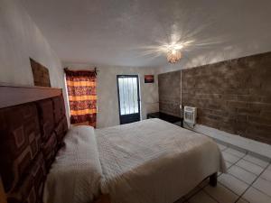 una camera con letto e muro di mattoni di Casa Nopal Tu casa vacacional tipo hotel a Creel