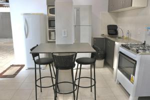 a kitchen with a table and stools in it at Hotel Residencial Manaus - Flores in Manaus