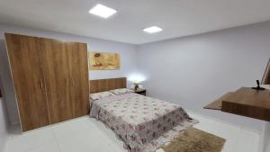 a bedroom with a bed and a wooden cabinet at Hotel Residencial Manaus - Flores in Manaus
