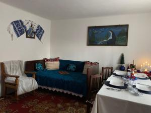 a living room with a blue couch and a table at CASA LUI MOȘU in Alba Iulia