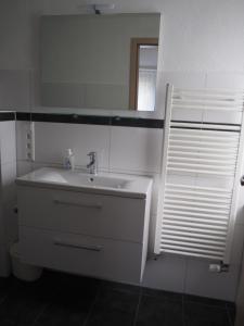 a white bathroom with a sink and a mirror at Ferienwohnung am Bach in Amtzell