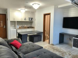 sala de estar con sofá y TV y cocina en Saint Sebastian Flat 213 - Com Hidro! até 4 pessoas, Duplex, no centro en Jaraguá do Sul