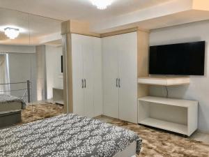 - une chambre avec un lit et une télévision à écran plat dans l'établissement Saint Sebastian Flat 213 - Com Hidro! até 4 pessoas, Duplex, no centro, à Jaraguá do Sul