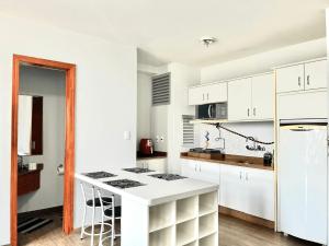 a kitchen with white cabinets and a white counter top at Saint Sebastian Flat 506 - Com Hidro! até 4 pessoas, Duplex, no centro in Jaraguá do Sul