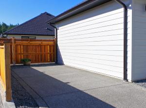 une porte de garage blanche sur le côté de la maison dans l'établissement Zen Retreat, à Victoria