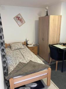 um quarto com uma cama, uma secretária e uma cadeira em Apartman Djokic 4 Studio em Pozarevac