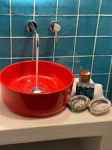 uma tigela vermelha com uma torneira a deitar-lhe água em Julietta Suites em Argostoli