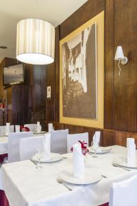 a dining room with white tables and a picture on the wall at Hostal Restaurante Alarico in Allariz