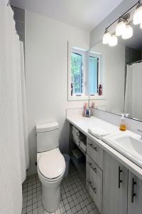 La salle de bains est pourvue de toilettes, d'un lavabo et d'un miroir. dans l'établissement Croissant des Soleils by Rendez-Vous Mont-Tremblant, à Mont-Tremblant