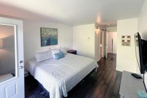 - une chambre avec un lit blanc et une télévision dans l'établissement Croissant des Soleils by Rendez-Vous Mont-Tremblant, à Mont-Tremblant