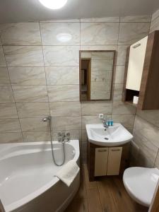 a bathroom with a tub and a sink and a toilet at Apartamenty przy Obrze in Skwierzyna +15 photos