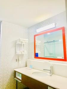 a bathroom with a sink and a red mirror at Hampton Inn by Hilton Port Hope Cobourg in Port Hope