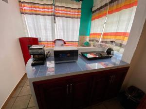 a kitchen with a counter top with a microwave at Hostal Mixteco Naba Nandoo in Oaxaca City