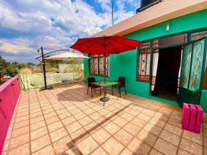 eine Terrasse mit einem Tisch und einem Sonnenschirm auf einem Haus in der Unterkunft Hostal Mixteco Naba Nandoo in Oaxaca de Juárez