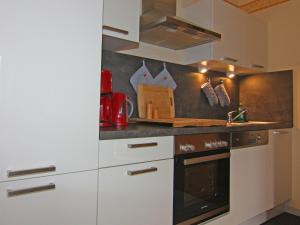 a kitchen with white cabinets and a stove at Apartment house, Lütow in Lütow