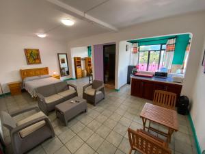 a bedroom with a bed and a living room at Hostal Mixteco Naba Nandoo in Oaxaca City